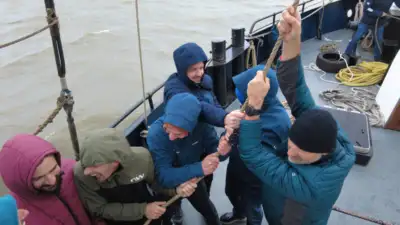 Guests help to raise the sails